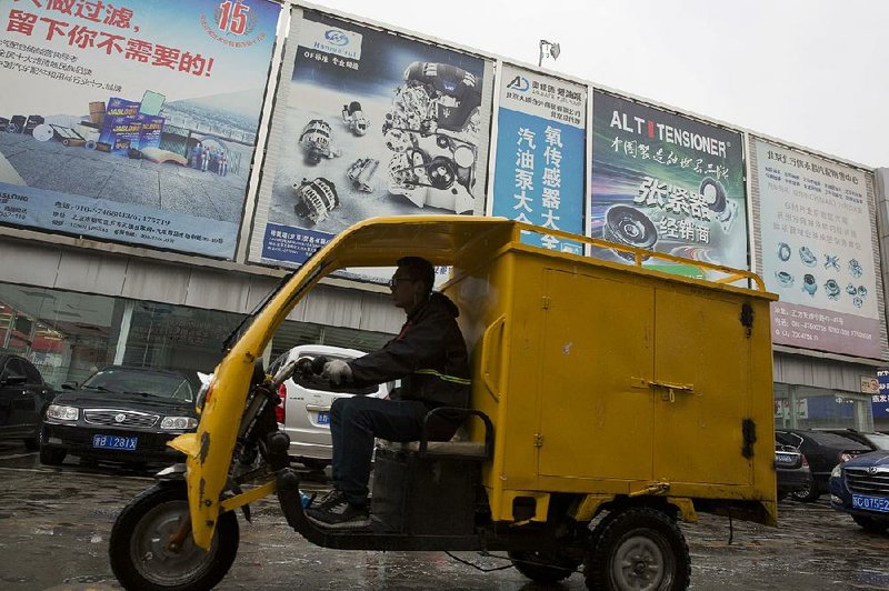 A delivery vehicle passes an auto parts market in Beijing on Friday. Chinese exporters of goods from electronics to motorcycle parts are seeking ways to avoid proposed U.S. tariff increases, such as rushing shipments to American customers ahead of the increases or finding other markets.
