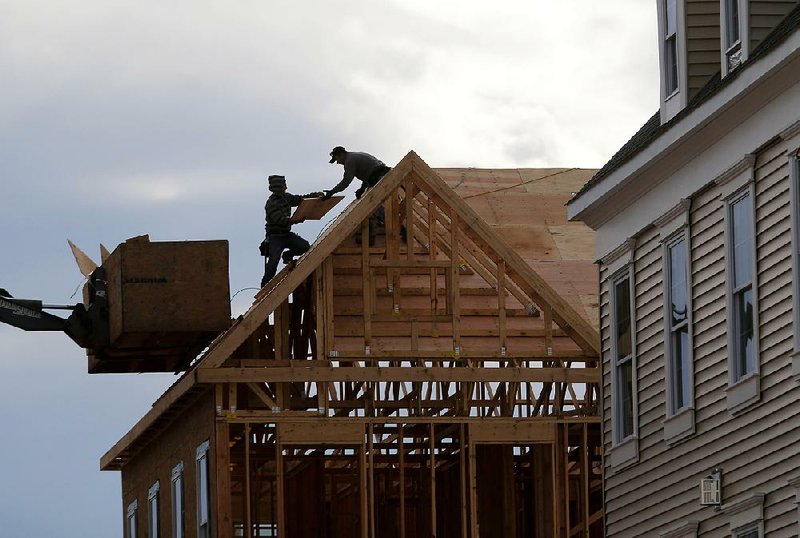 Construction workers build the roof of a town house in WoodRidge, N.J., in February.
