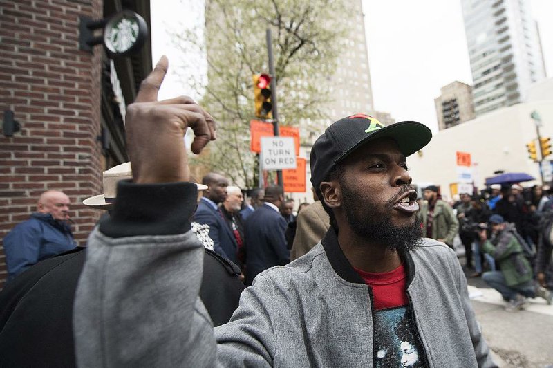 Protesters rally outside the Starbucks at 18th and Spruce streets in Philadelphia on Monday.