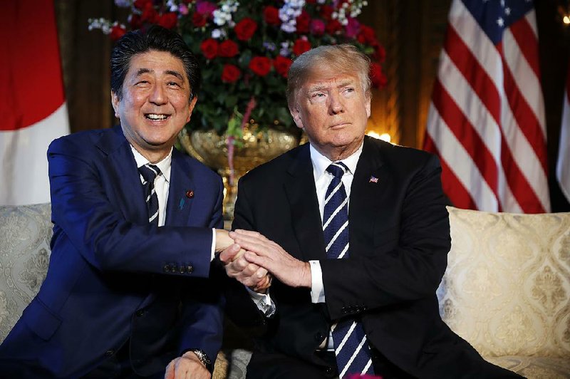 Japanese Prime Minister Shinzo Abe and President Donald Trump pose for photos Tuesday at Trump’s Mar-a-Lago club in Palm Beach, Fla., before holding talks on North Korea in private.  