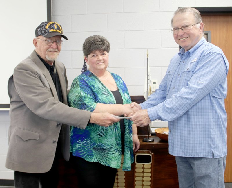 LYNN KUTTER ENTERPRISE-LEADER Carl Beutelschies, president of Lincoln Area Kiwanis Club, presents a $300 donation to Ken and Denise Ghenn of Prairie Grove. The couple runs a non-profit organization that raises money to help feed children in area schools.