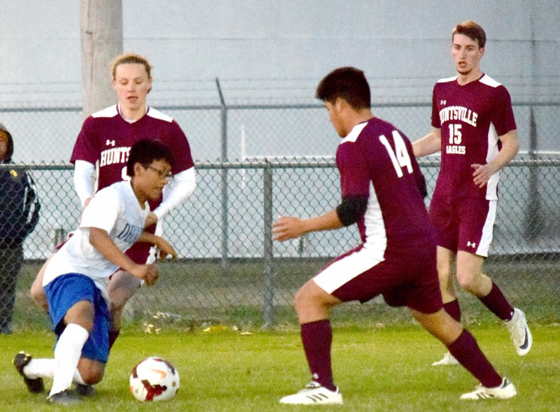 Westside Eagle Observer/MIKE ECKELS Bulldogs' Brayam Gomez (lower left) tries to fight his way out of a flight of Eagles on his way to the goal during the Decatur-Huntsville soccer match at Bulldog Stadium in Decatur April 9.