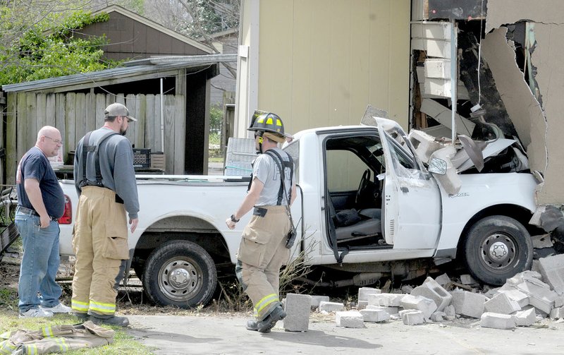 David Gottschalk NWA DEMOCRAT-GAZETTE Emergency personnel with Farmington Fire Department prepare to transport a small pickup truck after the vehicle drove into the Mandalay Asian Cuisine restaurant in Farmington on Wednesday, April 11. The driver was charged in connection with the accident.