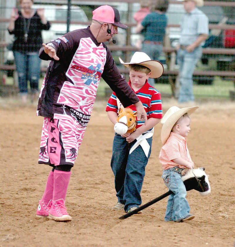MARK HUMPHREY ENTERPRISE-LEADER Jerry Casey, also known as "The Sarge," rodeo clown for the 64th annual Lincoln Rodeo directs traffic during the stick-horse grand entry. Ethan Parker, 2017 Lincoln Riding Club Lil' Mister, was about to have a runaway with his stick-horse mount and had to be cautioned not to run over a little cowboy bringing up the rear of the grand entry.