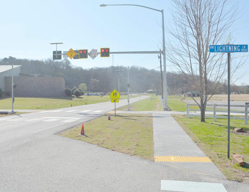 Keith Bryant/The Weekly Vista The new high-intensity activated crosswalk beacon, or HAWK crossing, across Mercy Way in front of Cooper Elementary, was finished last week. The crosswalk connects the school parking lot with a spur from the in-progress Razorback Greenway extension.