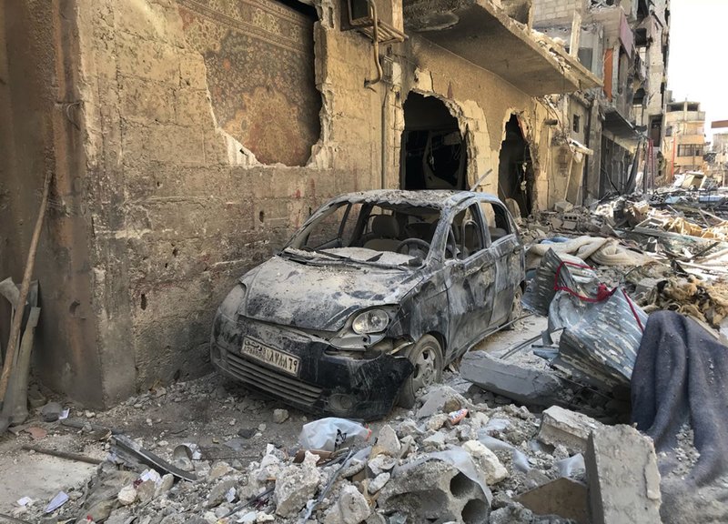 Rubble lines a street in Douma, the site of a suspected chemical weapons attack, near Damascus, Syria, Monday, April 16, 2018. Faisal Mekdad, Syria's deputy foreign minister, said on Monday that his country is "fully ready" to cooperate with the fact-finding mission from the Organization for the Prohibition of Chemical Weapons that's in Syria to investigate the alleged chemical attack that triggered U.S.-led airstrikes. (AP Photo/Hassan Ammar)