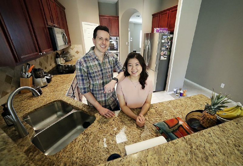 Rob Chilton and his wife, Saria, stand in their new house in Frisco, Texas. The first-time homebuyers said they paid more than they could comfortably afford to get a house near Dallas. 