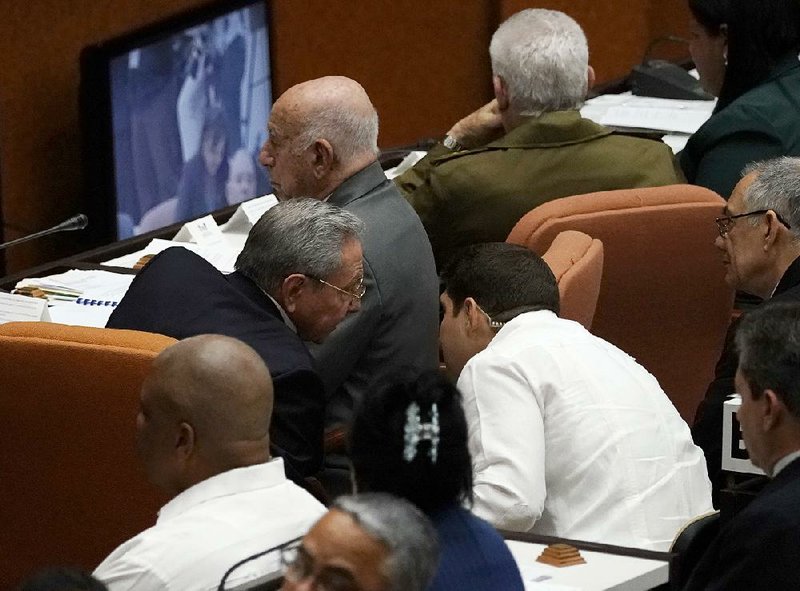 Cuban President Raul Castro confers Wednesday with grandson and bodyguard Raul Dominguez Castro Espin at the start of a two-day legislative session in Havana.  
