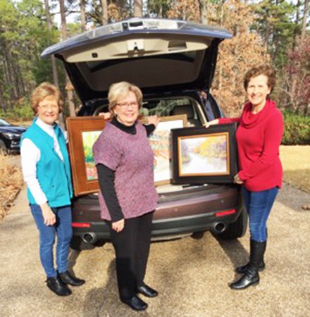 Submitted photo ART DONATION: From left, Hot Springs Village artists Caryl Joy Young, Barbara Seibel and Shirley Anderson load up their paintings to donate to the Arkansas Repertory Theatre in Little Rock.