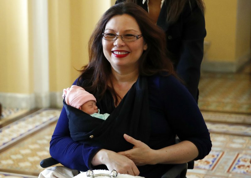 Sen. Tammy Duckworth, D-Ill., carries her baby Maile Pearl Bowlsbey after they went to the Senate floor to vote, on Capitol Hill, Thursday, April 19, 2018 in Washington. (AP Photo/Alex Brandon)