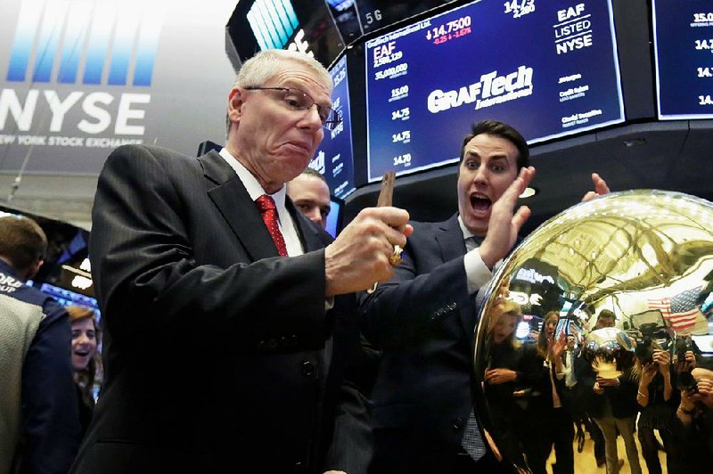 John Tuttle (right), the New York Stock Exchange global head of listings, reacts Thursday as GrafTech International Ltd. executive Dave Rintoul breaks the gavel while ringing a ceremonial bell to mark his company’s initial public offering.  