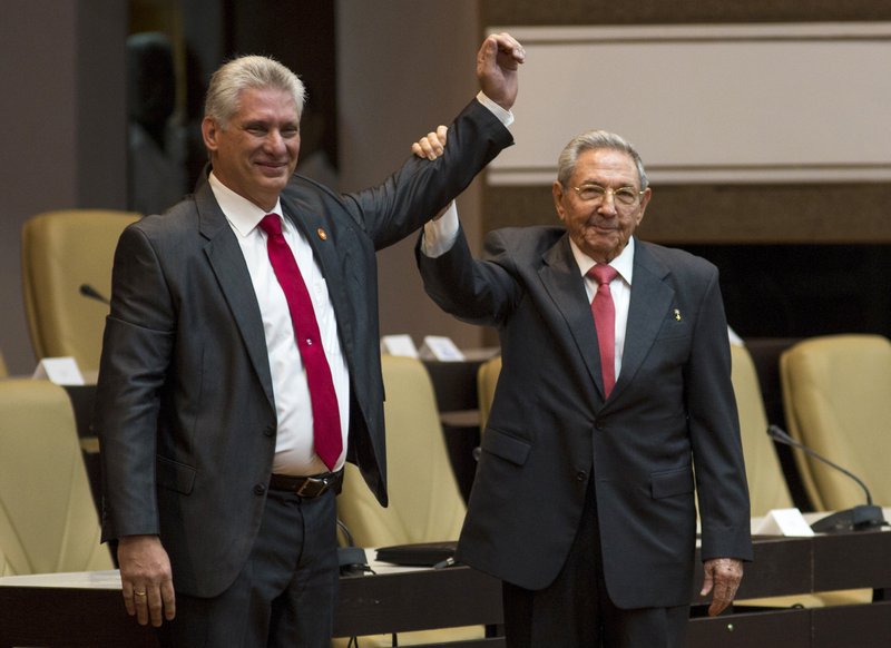 Cuba's new president Miguel Diaz-Canel, left, and former president Raul Castro, raise their arms after Diaz-Canel was elected as the island nation's new president, at the National Assembly in Havana, Cuba, Thursday, April 19, 2018. Castro left the presidency after 12 years in office when the National Assembly approved Diaz-Canel's nomination as the candidate for the top government position. (Irene Perez/Cubadebate via AP)