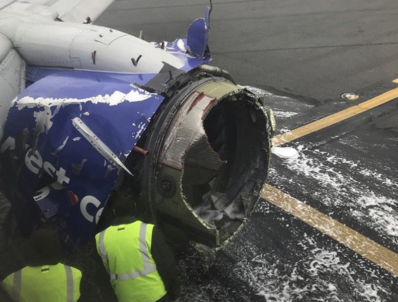 The engine on a Southwest Airlines plane is inspected as it sits on the runway at the Philadelphia International Airport after it made an emergency landing in Philadelphia, Tuesday, April 17, 2018. 