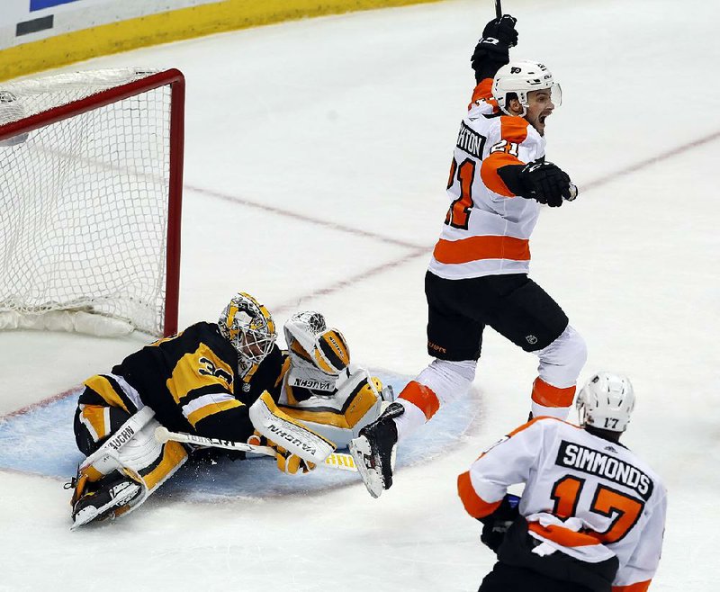 Philadelphia Flyers’ Scott Laughton (21) begins to celebrate after a shot by Sean Couturier got past Pittsburgh Penguins goaltender Matt Murray during the third period of the Flyers’ 4-2 victory. 