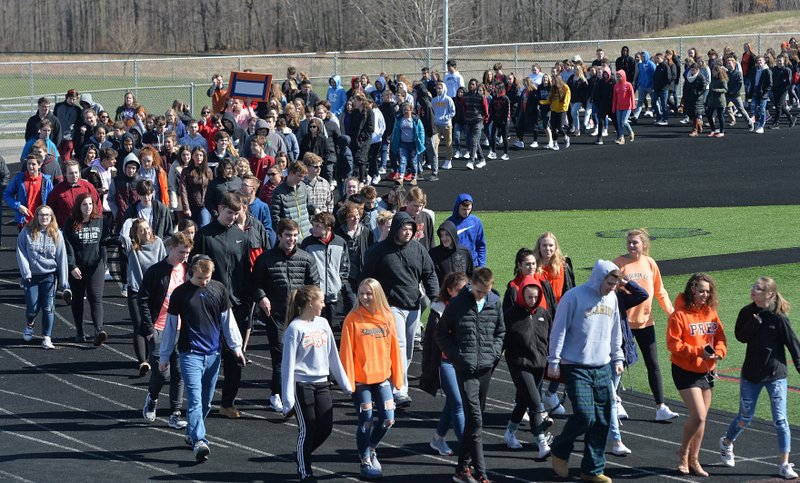 Fairview Middle and High School students taking part in a national school walkout event to protest gun violence and honor shooting victims at Fairview High School in Fairview Township, Erie County, Pa., Friday April 20, 2018. As part of the event, most of the students walked twice around the Keck Field running track twice. Protests were planned across the country Friday, on the 19th anniversary of the Columbine High School shooting. (Christopher Millette/Erie Times-News via AP)