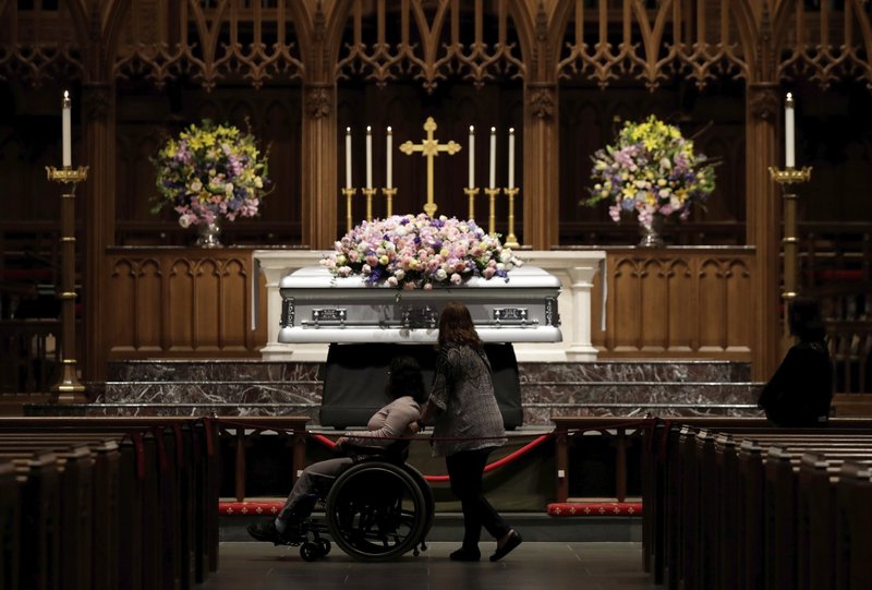 Mourners pause as former U.S. first lady Barbara Bush lies in repose during the visitation of former first lady Barbara Bush at St. Martin's Episcopal Church, Friday, April 20, 2018, in Houston. (AP Photo/Evan Vucci)