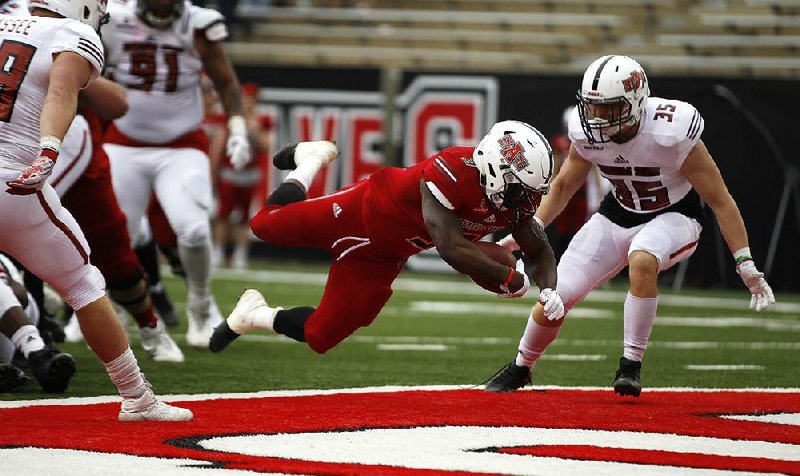 Arkansas State running back Jamal Jones dives into the end zone for a touchdown in front of safety Aaron Carter during the Red Wolves’ spring game Saturday at Centennial Bank Stadium in Jonesboro. See more photos at arkansasonline.com/galleries.  