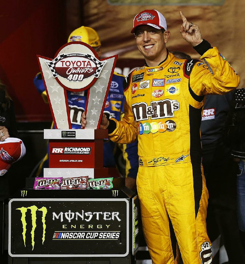 Kyle Busch poses with the winners trophy as he celebrates in Victory Lane after winning the NASCAR Cup Series auto race at Richmond Raceway in Richmond, Va., Saturday, April 21, 2018. 