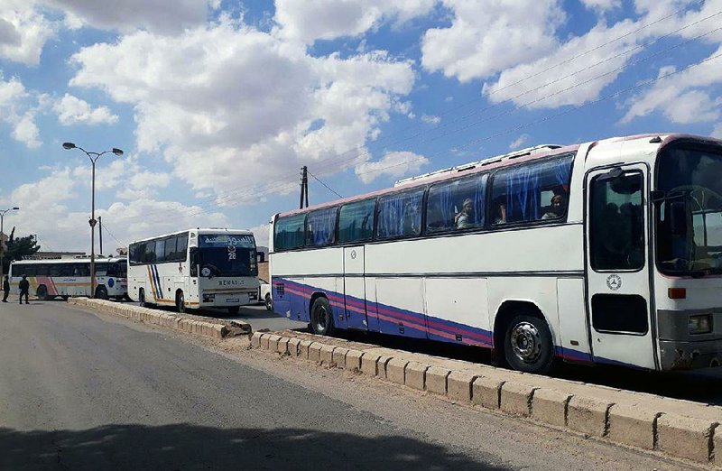 Buses in a convoy carry rebels and their families Saturday as they evacuate Ruhaiba, Jayroud and al-Nasriya in the eastern Qalamoun region of Syria. 
