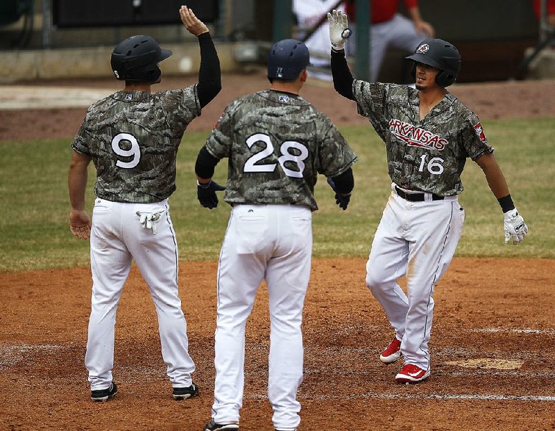 Arkansas Travelers second baseman Chris Mariscal (right) celebrates with teammates Dario Pizzano and Ryon Healy after his three-run home run Sunday against the Springfield Cardinals. 