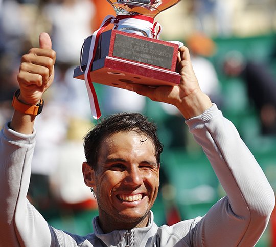 Spain's Rafael Nadal holds the trophy as he celebrates winning the men's singles final match of the Monte Carlo Tennis Masters tournament against Japan's Kei Nishikori in two sets, 6-3, 6-2, in Monaco, Sunday April 22, 2018. (AP Photo/Christophe Ena)