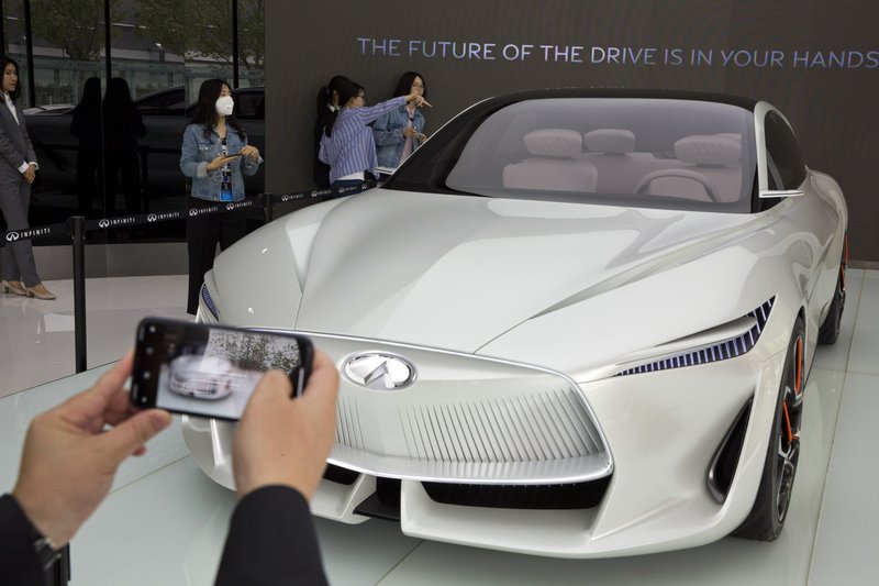 In this April 19, 2018, photo, visitors look at the Infiniti electric concept sedan at a showroom ahead of the Auto China 2018 to be held in Beijing, China. Auto China 2018, the biggest global auto show of the year, showcases China's ambitions to become a leader in electric cars and the industry's multibillion-dollar scramble to roll out models that appeal to price-conscious but demanding Chinese drivers. (AP Photo/Ng Han Guan)