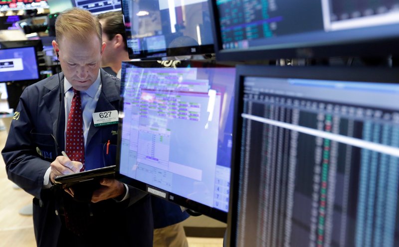 Trader Michael Smython the floor of the New York Stock Exchange on Monday. U.S. stocks were mixed Monday morning as health care and industrial companies make gains and energy companies slip with oil prices. (AP Photo/Richard Drew)