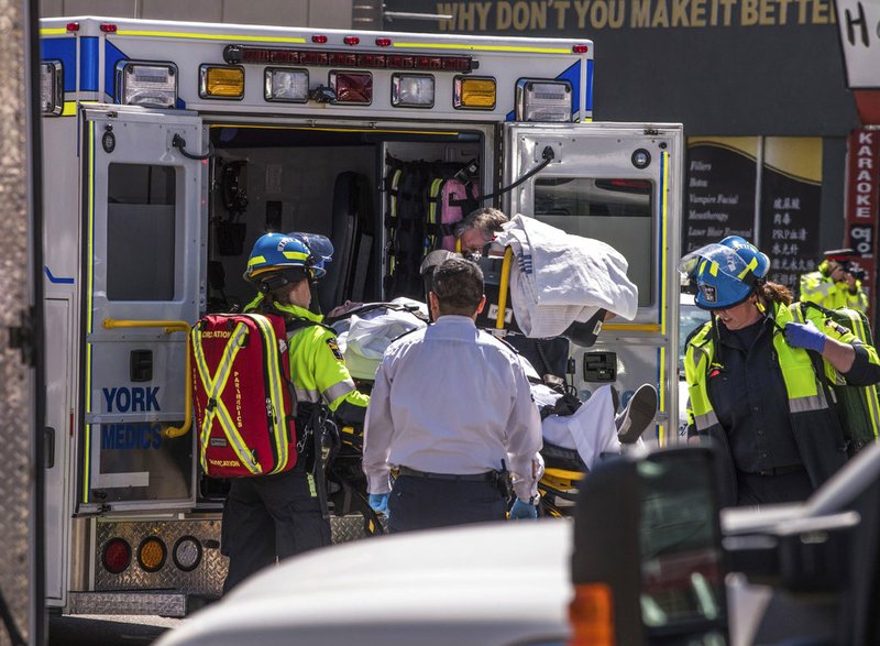An injured person is put into the back of an ambulance in Toronto after a van mounted a sidewalk crashing into a crowd of pedestrians Monday, April 23, 2018. 