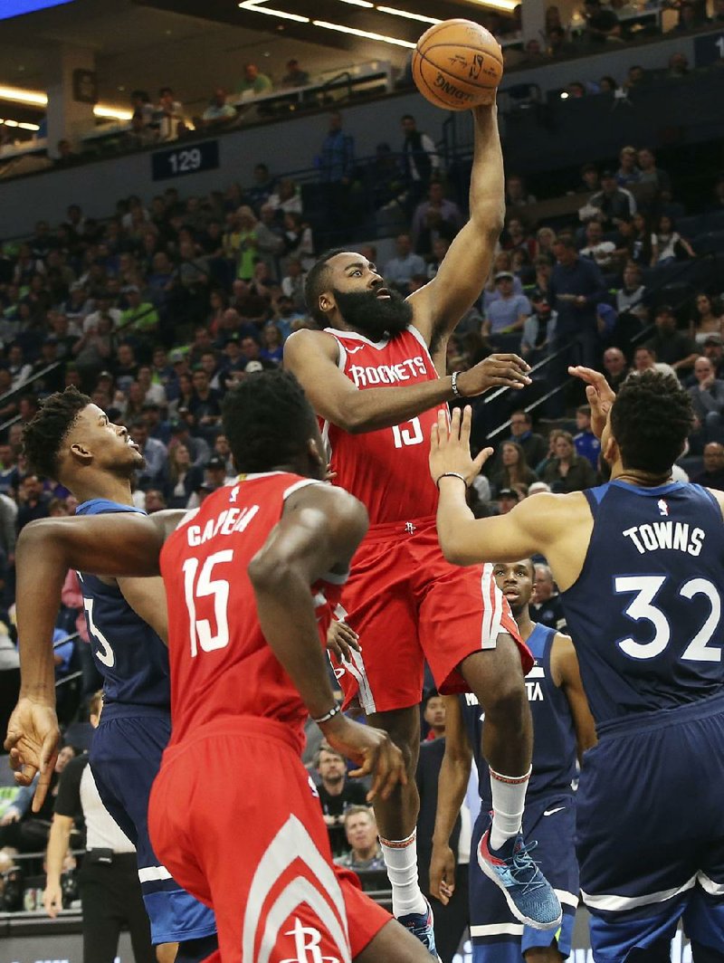 Houston Rockets guard James Harden (center) attempts a shot as Minnesota’s Karl-Anthony Towns (right) defends during the second half of Game 4 of the NBA Western Conference first round Monday night at the Target Center in Minneapolis. 