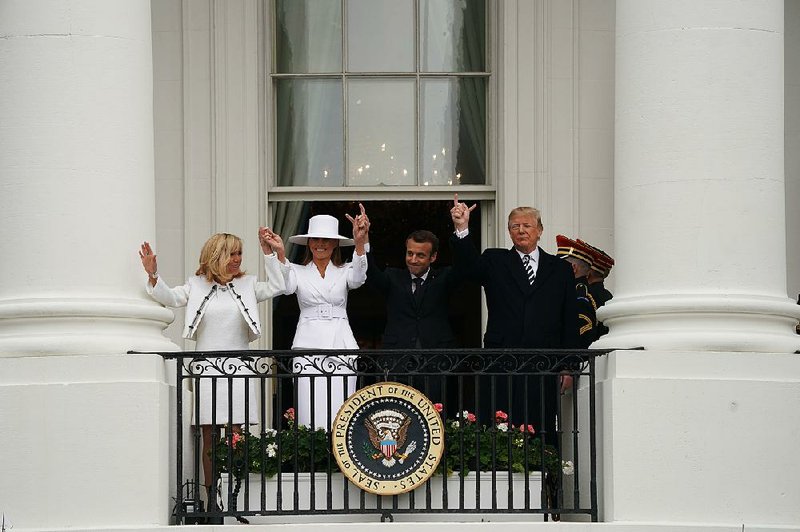 Brigitte Macron and Melania Trump join their husbands on the White House balcony Tuesday during a state arrival ceremony for French President Emmanuel Macron.  