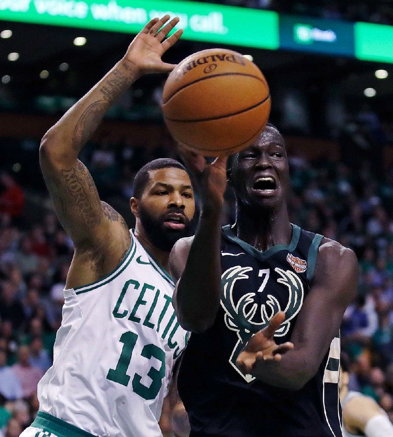 Milwaukee Bucks center Thon Maker (right) passes as he is pressured by Boston Celtics forward Marcus Morris during Game 5 of their NBA playoff series Tuesday night in Boston.  
