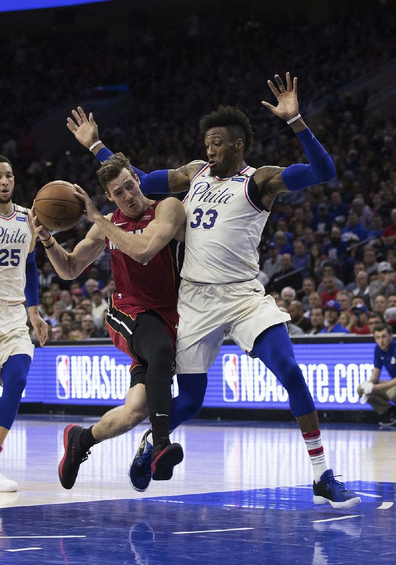 Robert Covington (right) of the Philadelphia 76ers defends against Goran Dragic of the Miami Heat in the 76ers’ series-clinching victory Tuesday night in Philadelphia. 