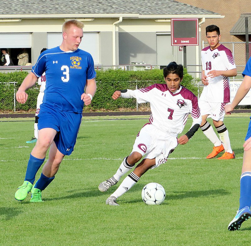 Westside Eagle Observer/RANDY MOLL Gentry freshman Angel Martinez moves the ball toward past Bergman defenders in the Gentry-Bergman game at Gentry High School on Thursday (April 19, 2018).