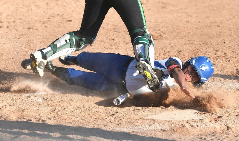 NWA Democrat-Gazette/J.T. WAMPLER Rogers High's Cassie Gonzalez slides in to home plate under Van Buren catcher Janelle Parga for the winning run Tuesday at Veterans Park in Rogers.