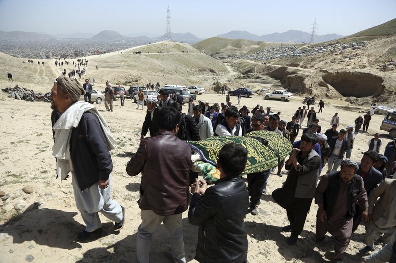 Men carry the coffin of a relative who died in Sunday's suicide attack at a voter registration center, in Kabul, Afghanistan, Monday, April 23, 2018. Taliban attacks in western Afghanistan killed 14 soldiers and policemen on Monday as residents in the capital, Kabul, prepared for the funerals of those killed in the horrific bombing by the Islamic State group on a voter registration center that left at least 57 dead the previous day. (AP Photo/Rahmat Gul)