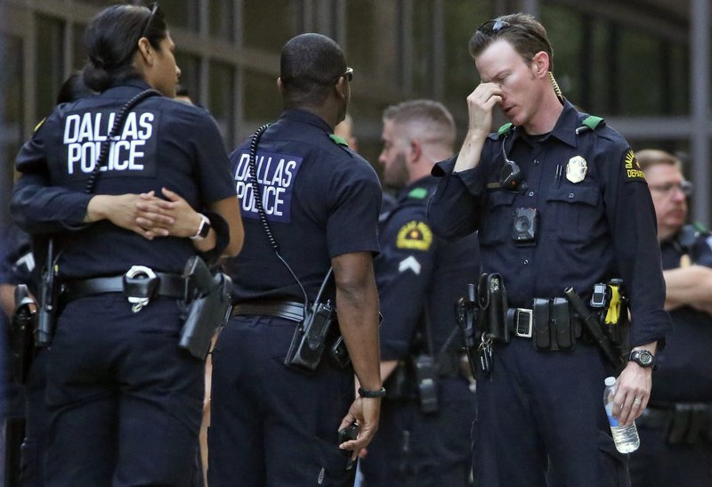 Dallas Police officers wait outside the entrance of the emergency room at Presbyterian Hospital, Tuesday, April 24, 2018, in Dallas, following a shooting at an area Home Depot where two police officers and a civilian were shot. The officers were critically wounded in the shooting, according to officials. 