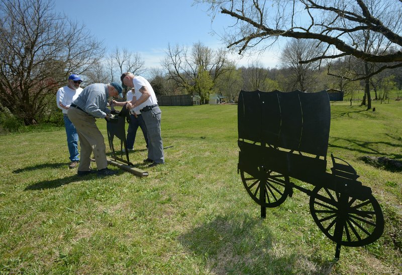 NWA Democrat-Gazette/ANDY SHUPE Bob Ashbaugh (from left), Gary Burney, Rick Johnson and John Thompson, all volunteers with the Elm Springs Heritage Association, install silhouettes of Civil War soldiers last week in the city's park adjacent to the association's facility in Elm Springs. The park was once the site of a large camp of Confederate soldiers.