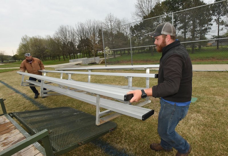 SOCCER SEATING NWA Democrat-Gazette/FLIP PUTTHOFF Chris Cooper (left) and Mark Townsend, both with Rogers' Parks and Recreation Department, move bleachers Wednesday at the Veterans Park soccer fields. The men moved bleachers while converting the soccer fields from youth league configuration to adult league.