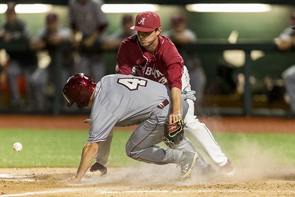 Troy's Matt Sanders (4) scores on a passed ball as Alabama pitcher Kyle Cameron (33) covers the plate during a college baseball game Tuesday, April 24, 2018, in Tuscaloosa, Ala. (Vasha Hunt/AL.com via AP)

