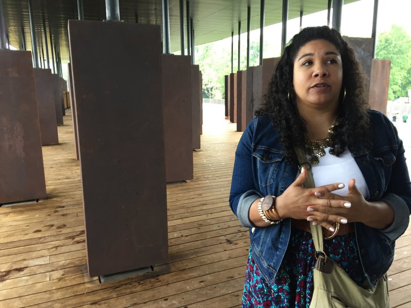 Angel Smith Dixon stands inside a display at the National Memorial for Peace and Justice, a new memorial to honor people killed in racist lynchings, which opened to the public Thursday, April 26, 2018, in Montgomery, Ala. Smith Dixon who came from Lawrenceville, Ga., to see the memorial said, "We're publicly grieving this atrocity for the first time as a nation. ... You can't grieve something you can't see, something you don't acknowledge. Part of the healing process, the first step is to acknowledge it." 