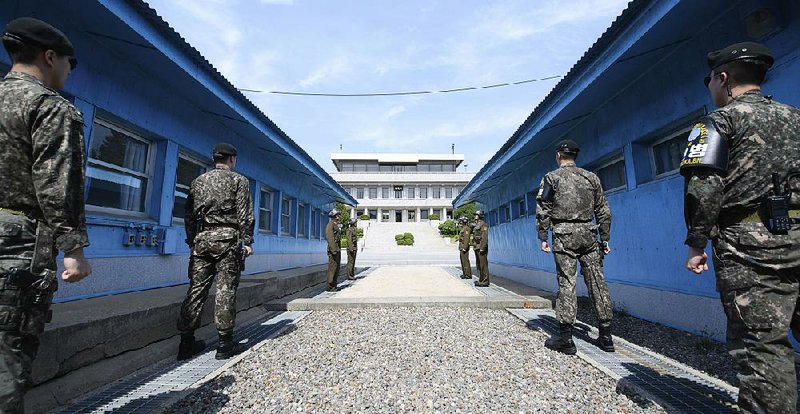 Four North Korean soldiers (rear) and four South Korean soldiers stand Thursday at the border in Panmunjom in the Korean Demilitarized Zone.  