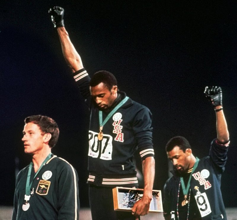 In this Oct. 16, 1968, file photo, Australian silver medalist Peter Norman, left, stands on the podium as Americans Tommie Smith, center, and John Carlos raise their gloved fists in a human rights protest. Australian Olympic Committee (AOC) awarded on Saturday, April 28, 2018, a posthumous Order of Merit to Norman. AOC President John Coates said that Norman's achievements as an athlete - his silver-medal winning time of 20.06 seconds at Mexico City remains an Australian record 50 years after he set the mark - were dwarfed by his support for the gold and bronze medalists who raised their gloved fists and bowed their heads during the American national anthem. (AP Photo, File)
