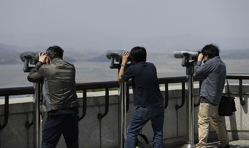 Visitors in Paju, South Korea, use binoculars Saturday to look at the North Korean side of the border from an observatory.  