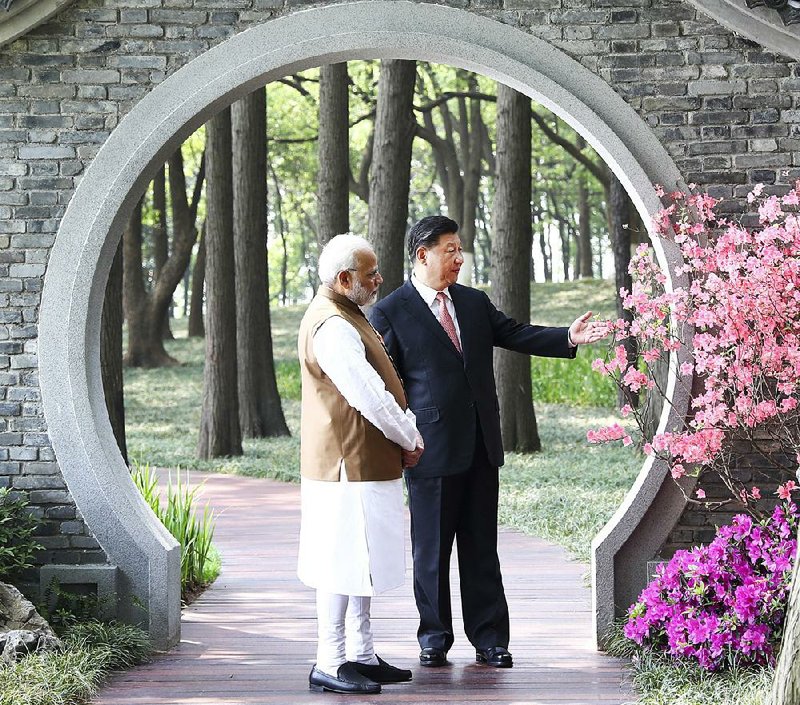 Indian Prime Minister Narendra Modi (left) and Chinese President Xi Jinping talk Saturday in a garden in Wuhan, China.  