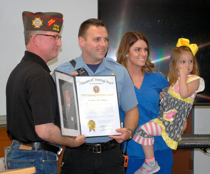 Janelle Jessen/Siloam Sunday Ashley Little, Commander of the Veterans of Foreign Wars Department of Arkansas, presented Kyle Huffman, a firefighter and paramedic with the Siloam Springs Fire Department, with a Gold Badge Public Servant Award on Monday as Huffman's wife, Sophia Huffman, and daughter, Kendee Huffman, looked on.