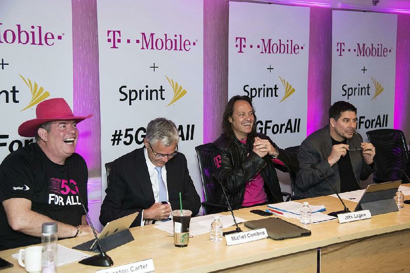 T-Mobile CFO Braxton Carter (from left) joins Sprint CFO and President Michel Combes, T-Mobile CEO John Legere and Sprint CEO Marcelo Claure as they share details Sunday in New York to announce the companies’ merger. 
