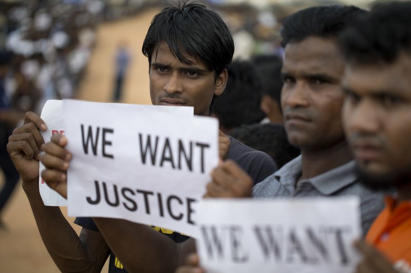 Rohingya refugees holing placards, await the arrival of a U.N. Security Council team at the Kutupalong Rohingya refugee camp in Kutupalong, Bangladesh, Sunday, April 29, 2018. A U.N. Security Council team visiting Bangladesh promised Sunday to work hard to resolve a crisis involving hundreds of thousands of Rohingya Muslims who have fled to the country to escape military-led violence in Myanmar. (AP Photo/A.M. Ahad)