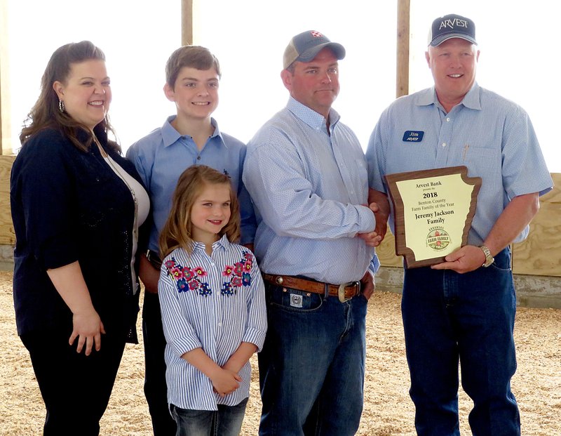 Westside Eagle Observer/RANDY MOLL Jeremy Jackson, along with his wife Michelle, son Wyatt and daughter Emily, received the Benton County Farm Family of the Year Award from Jim Singleton, chairman of the selection committee at ceremonies at the Jackson Farm on Tuesday, May 1, 2018.