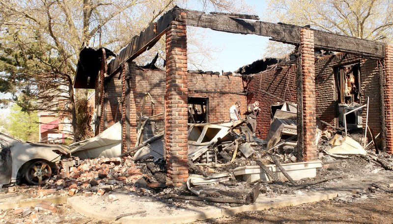 LYNN KUTTER ENTERPRISE-LEADER Washington County Fire Marshal Tyler McCartney, left, and Justin Cox, assistant fire marshal, investigate the cause of a house fire in Prairie Grove on Saturday morning.