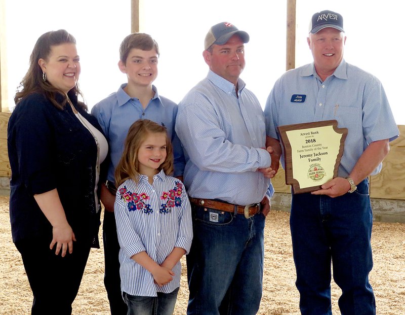 NWA Democrat-Gazette/RANDY MOLL Jeremy Jackson (center left), along with his wife Michelle, son Wyatt and daughter Emily, received Tuesday the Benton County Farm Family of the Year award from Jim Singleton (right), chairman of the selection committee at the Jackson farm.